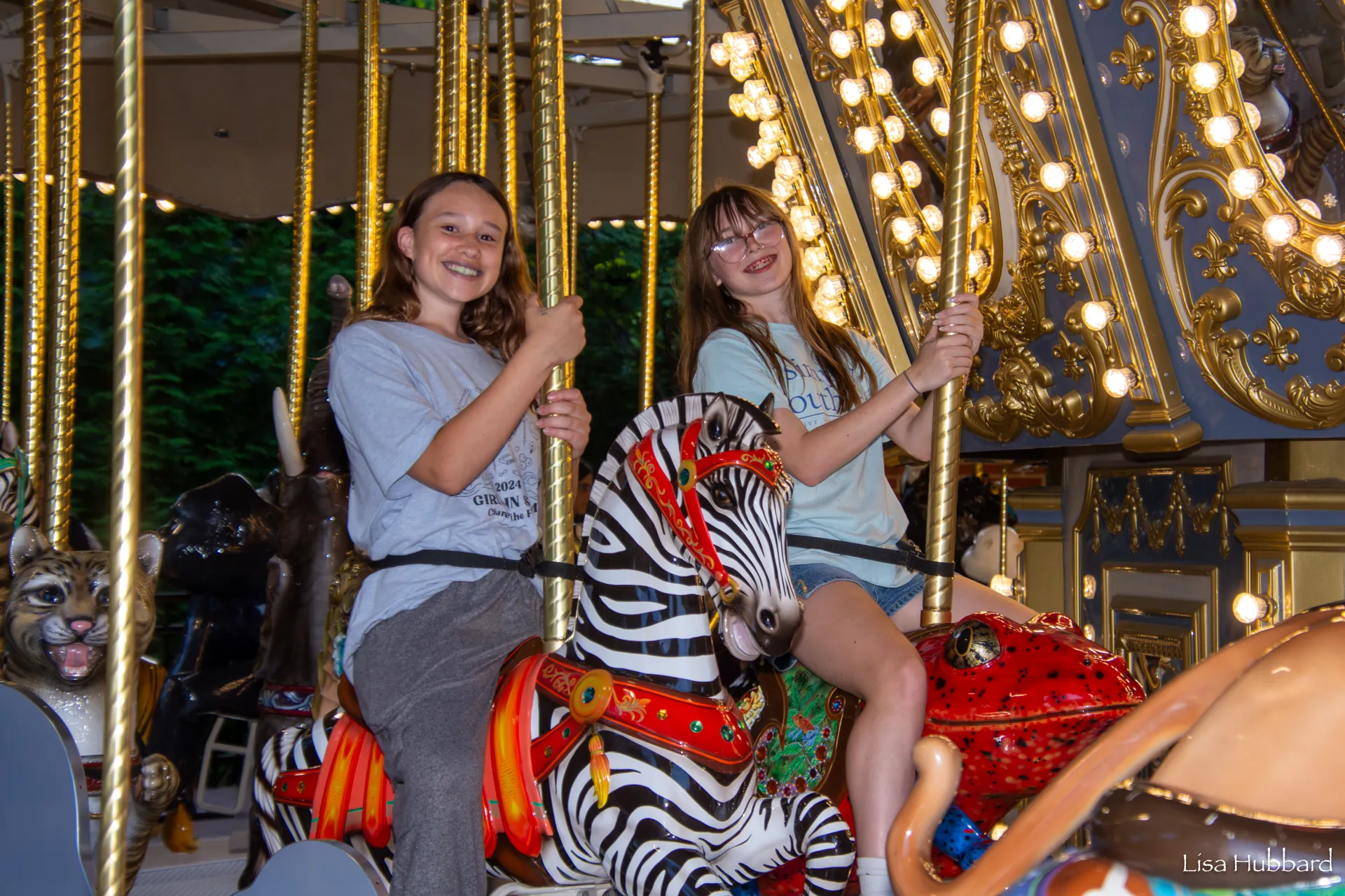2 kids riding the carousel